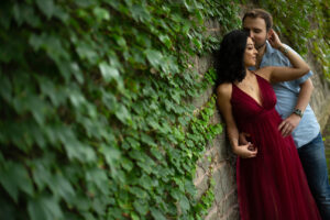 An engaged couple, in a delicate embrace, leaning against an ivy covered old brick wall, photographed in Milton, Ontario by Mike Streeter